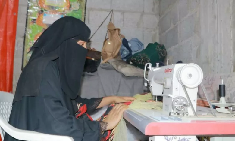 سيدة يمنية تعمل في ماكينة الخياطة