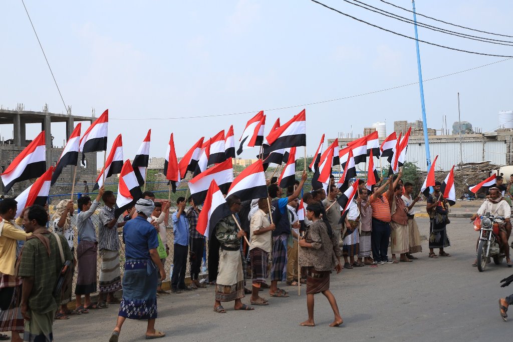 يمنيون يحملون الراية الوطنية في ذكرى ثورتي سبتمبر وأكتوبر